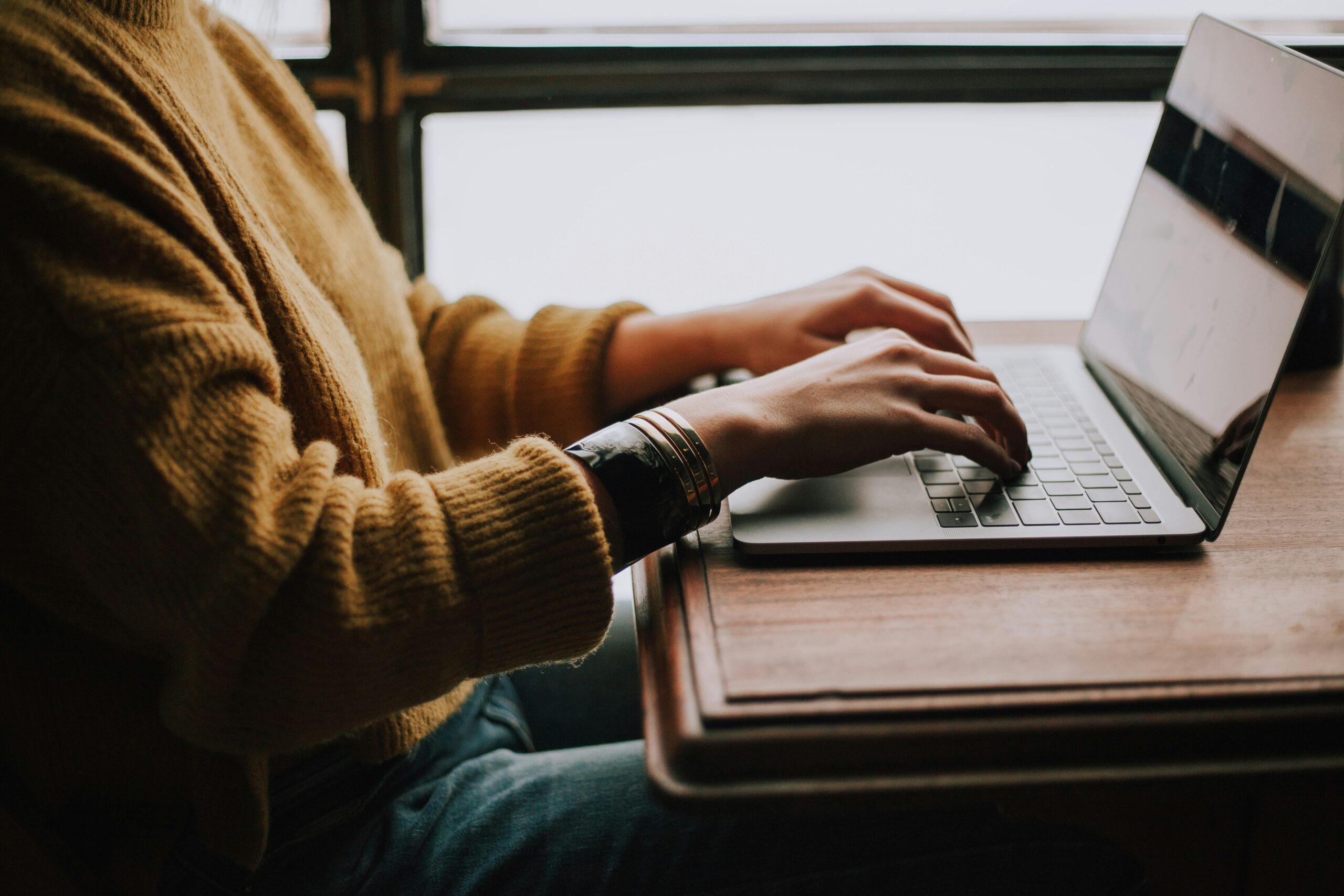 Zoomed in photo of someone typing on the computer.