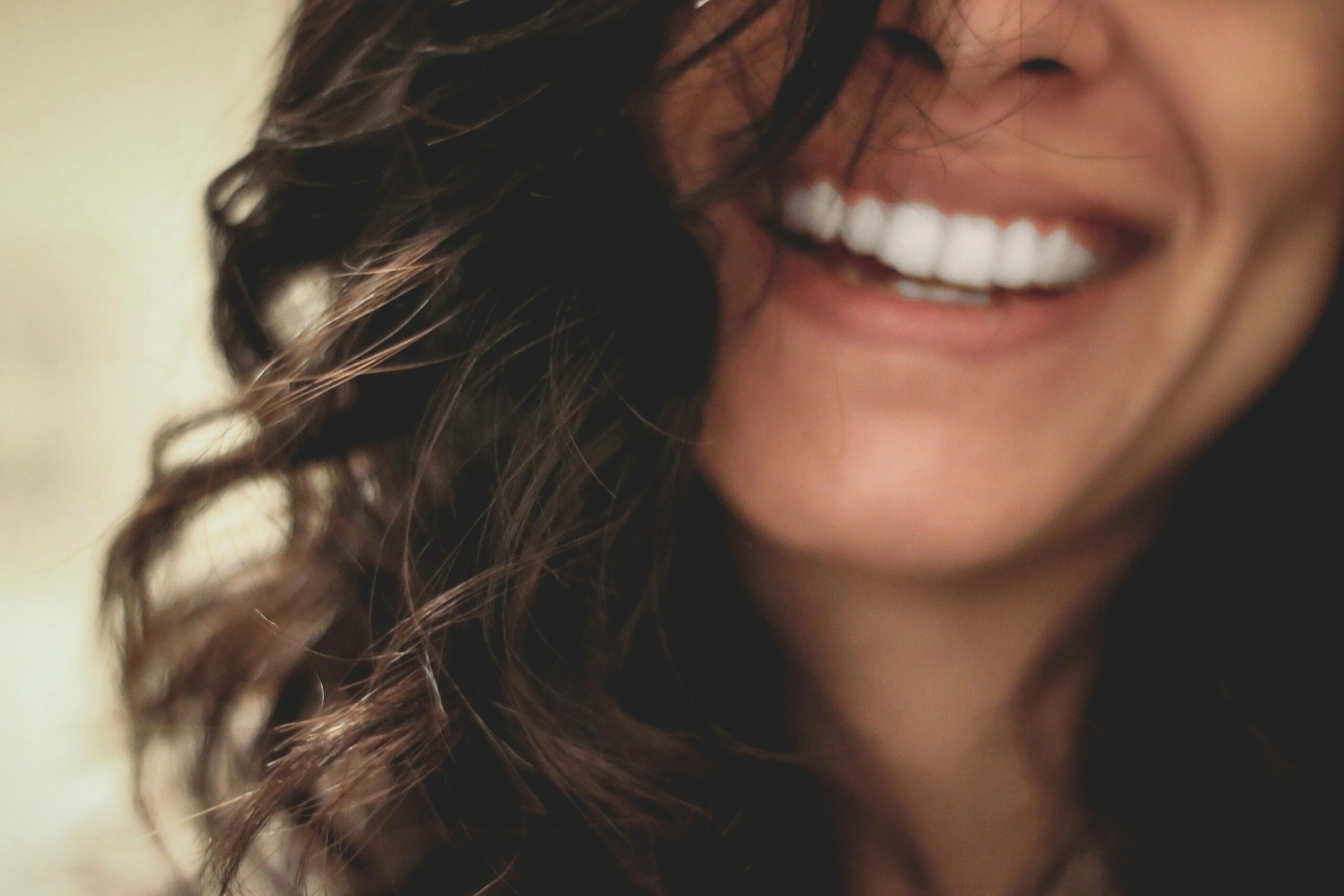 A zoomed in pictre of a woman smiling.