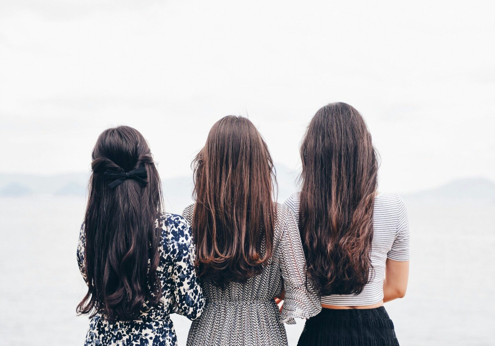 3 women standing with their back to the camera.